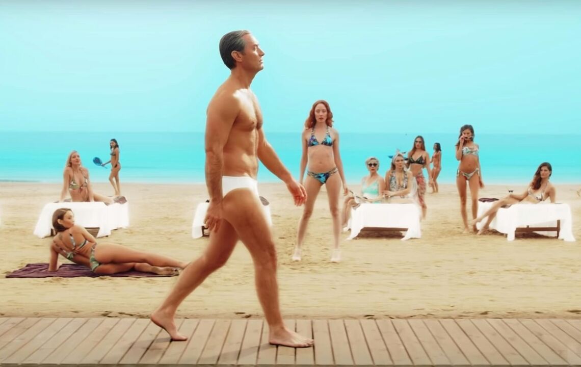 Girls on the beach stare at a man enlarging his penis